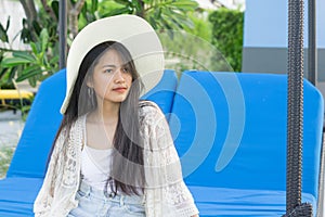 Beautiful girl relaxing on a resort wearing a straw hat