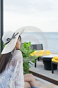 Beautiful girl relaxing on a resort wearing a straw hat