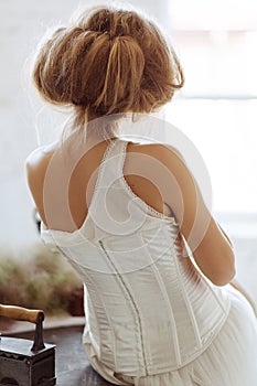 Beautiful girl in retro clothes with old iron. Retro style on a white background