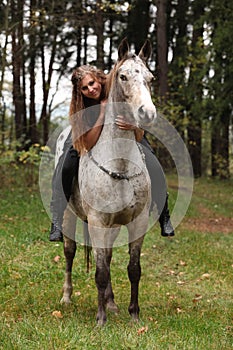 Beautiful girl riding a horse without bridle or saddle
