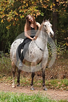 Beautiful girl riding a horse without bridle or saddle