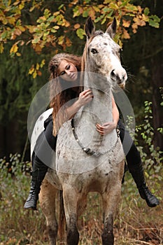 Beautiful girl riding a horse without bridle or saddle