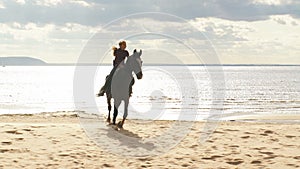 A beautiful girl riding a horse at a lake. Beautiful view