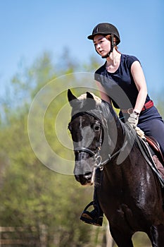 Beautiful girl riding a horse on manege