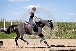 Beautiful girl riding a horse on manege