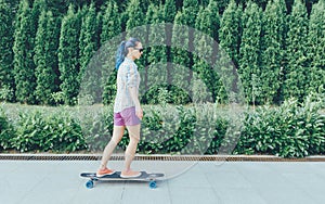 Beautiful girl riding a longboard outdoor.