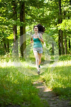 Beautiful girl running through forest