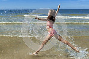 Beautiful girl running and jumping on the beach