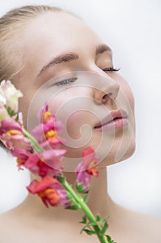 Beautiful girl`s face with color flower near