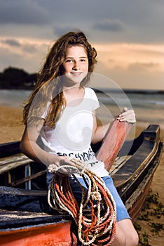 Beautiful girl sailor posing in boat at the coast