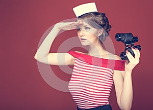 Beautiful girl sailor with a vintage binoculars and looks into the distance