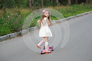 Beautiful girl with scooter on the road