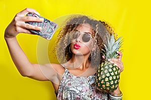 Beautiful Girl selfie with a smartphone. Beautiful young African American woman with afro hairstyle and sunglasses