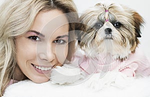 Beautiful girl with shih tzu, smiling with a puppy, in pink clothes