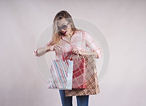 Beautiful girl with shopping bags in jeans sunglasses studio