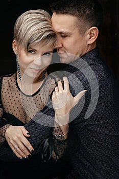 Beautiful girl with short hair embraces her man. The concept of love and relationships. Portrait. Close-up
