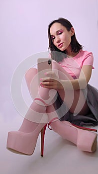 Beautiful girl is sitting in a fashionable puffy gray skirt and pink blouse