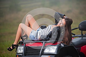 Beautiful girl sitting on four-wheeler ATV