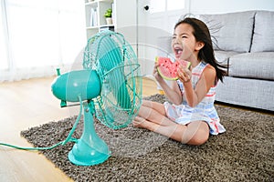 Beautiful girl sitting in front of electric fan