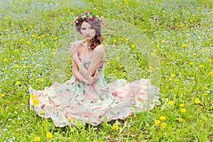 Beautiful girl sitting on the ground near the wall in jeans and a white blouse , her hair develops wind photo