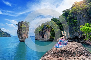 Beautiful girl sitting on the rock at James Bond island in Phang nga, Thailand. photo