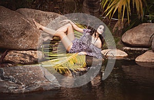 Beautiful girl sitting on stones