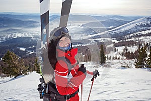 A beautiful girl skier with a backpack behind her shoulders is doing backcountry