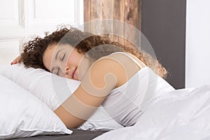 Beautiful girl sleeping in bed alone.