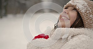 Beautiful girl in snowflakes getting warm in winter forest