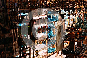 Beautiful girl in a souvenir shop in Turkey. Girl chooses a souvenir Oriental shop. Street shop. Turkish Souvenirs. Oriental