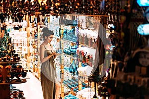 Beautiful girl in a souvenir shop in Turkey. Girl chooses a souvenir Oriental shop. Turkish Souvenirs. Oriental bazaar.