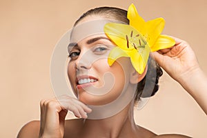 Beautiful girl in spa with flower near her face