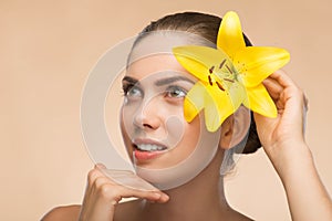 Beautiful girl in spa with flower near her face