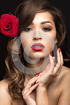 Beautiful girl in the Spanish way of Carmen with red lips and a rose in her hair.