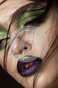 Beautiful girl with spring green makeup and vampire lips. beauty face.