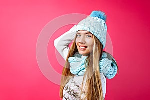 Beautiful girl standing isolated on red background, in warm blue