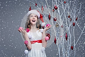 Beautiful girl standing near tree with christmas decorations