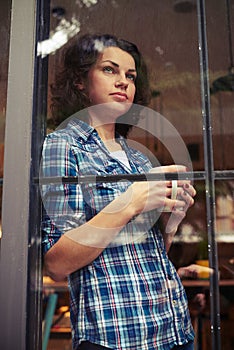 Beautiful girl standing near window