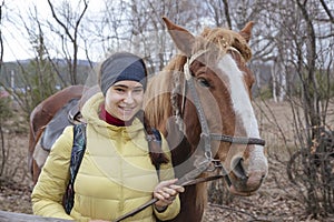 A beautiful girl stands with a horse.