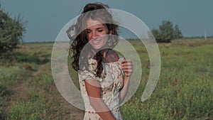 A beautiful girl in the steppe. Slow-motion authentic video. A beautiful young girl turns and smiles at he camera.