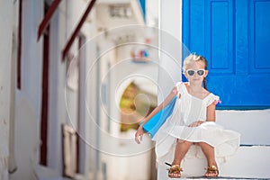 Beautiful girl at street of typical greek traditional village on Mykonos