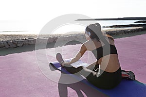 Beautiful girl stretching in front of the beach after exercising