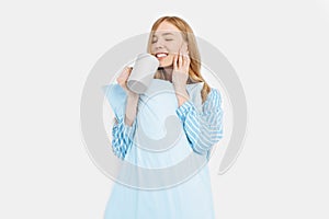 Beautiful girl in striped pajamas, with a Cup in her hands , drinking coffee or tea in the early morning