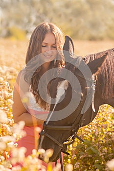 beautiful girl stroking her horse& x27;s head