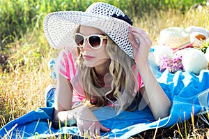 Beautiful girl sunbathing on nature in a hat