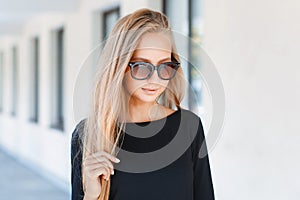 Beautiful girl in sunglasses on background of windows