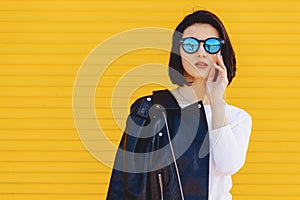 Beautiful girl sunglasses on bright yellow background