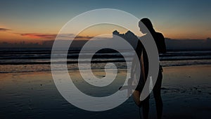 beautiful girl with a surfboard at sunset.