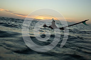 beautiful girl with a surfboard at sunset.