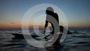 beautiful girl with a surfboard at sunset.